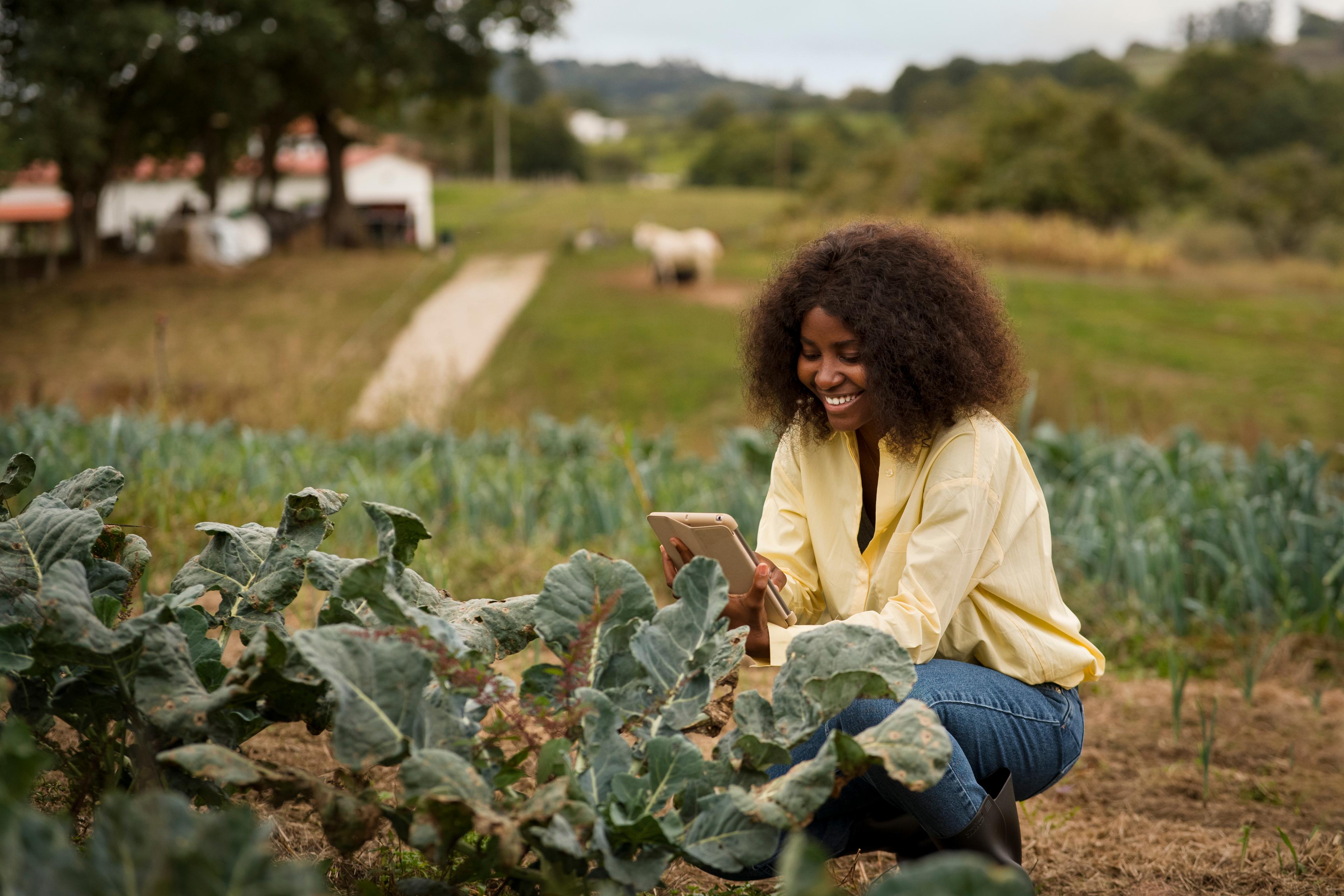 Farmer using technology in agricultural field - representing our mission to transform Africa's agriculture